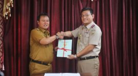 Pj. Bupati Lampung Barat, Nukman menerima 100 sertifikat aset milik Pemkab Lambar dari Kepala BPN Lambar, Oki Maradha Pratama. Foto: Humas Pemkab Lampung Barat