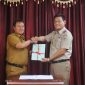 Pj. Bupati Lampung Barat, Nukman menerima 100 sertifikat aset milik Pemkab Lambar dari Kepala BPN Lambar, Oki Maradha Pratama. Foto: Humas Pemkab Lampung Barat