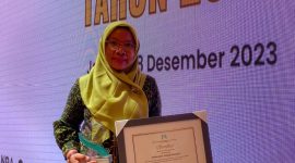 Kepala Puskesmas Tulang Bawang 1, Meliana, menerima penghargaan tematik Pemenuhan Hak Anak dari Kementerian KPPA di Gedung Auditorium Perpusnas RI. Foto: Dokumentasi Dinas KPPA Tulang Bawang.