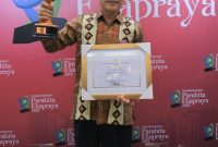 Pj Bupati Tulang Bawang, Qudrotul Ikhwan mengangkat penghargaan Parahita Ekapraya dari Kementerian PPPA. Foto: Dinas Kominfo Tulang Bawang