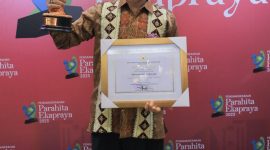 Pj Bupati Tulang Bawang, Qudrotul Ikhwan mengangkat penghargaan Parahita Ekapraya dari Kementerian PPPA. Foto: Dinas Kominfo Tulang Bawang