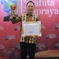Pj Bupati Tulang Bawang, Qudrotul Ikhwan mengangkat penghargaan Parahita Ekapraya dari Kementerian PPPA. Foto: Dinas Kominfo Tulang Bawang