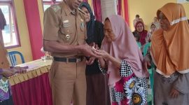 Pj. Peratin Gedung Surian, Calim menyerahkan bantuan langsung tunai (BLT) Dana Desa Tahun 2023 pada 23 KPM. Foto: Kristian Agusani, Kabar Indonesia.