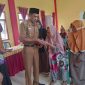 Pj. Peratin Gedung Surian, Calim menyerahkan bantuan langsung tunai (BLT) Dana Desa Tahun 2023 pada 23 KPM. Foto: Kristian Agusani, Kabar Indonesia.