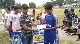I Gusti Kadek Artawan menyerahkan hadiah pada Juara Piala Ascab PSSI U-16 Kabupaten Pesisir Barat, Armada, di Lapangan Merdeka Labuhan Jukung pada Sabtu (23/12/2023). Foto: Joni Irawan, Kabar Indonesia.