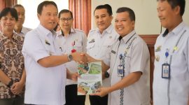 Pj Bupati Lampung Barat, Nukman menyerahkan buku road map Peran dan Komitmen Multipihak Terhadap Mitigasi Konflik Satwa dan Peningkatan Ekonomi Masyarakat Berkelanjutan 2023-2028 di Lampung Barat. Foto: Haerul Abadi, Kabar Indonesia