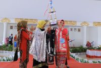 Seorang juara Lomba Fashion Show Kebaya Maduaro dalam rangka peringatan Hari Ibu Ke-95 di Kabupaten Tulang Bawang mengangkat piala. Foto: Andi Rahman, Kabar Indonesia.