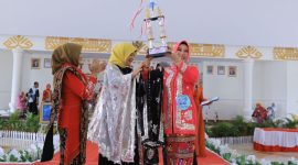 Seorang juara Lomba Fashion Show Kebaya Maduaro dalam rangka peringatan Hari Ibu Ke-95 di Kabupaten Tulang Bawang mengangkat piala. Foto: Andi Rahman, Kabar Indonesia.