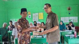 Penyerahan dokumen SK Pengangkatan Kepsek MI BUA dari Ketua Yayasan Nafian Faiz kepada  H.Zainuddin. Foto: Humas MI BUA