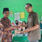 Penyerahan dokumen SK Pengangkatan Kepsek MI BUA dari Ketua Yayasan Nafian Faiz kepada  H.Zainuddin. Foto: Humas MI BUA