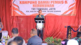 Pj. Bupati Tulang Bawang Qudrotul Ikhwan memukul gong tanda Launching Kampung Damai Pemilu dan Kerukunan di Kampung Tri Tunggal Jaya pada Jum'at (2/2/2024). Foto: Andi Rahman, Kabarindonesia.co