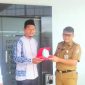 Kepala Dinas DPMPTSP Tulang Bawang Barat Ahmad Hariyanto menerima cindera mata dari Guru MA PSS Istiqomah Islamiyah Rusdiansyah di Mall Pelayanan Publik Tubaba pada Selasa (6/2/2024). Foto: Andi Rahman, Kabarindonesia.co