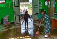 Seorang warga tampak membersihkan ruang kelas setelah Desa Ketenong 2 dilanda banjir pada Senin (5/2/2024). Foto: Melki Agustian, Kabarindonesia.co