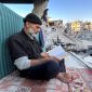 Seorang pengungsi Gaza membaca Al-Qur'an di tengah reruntuhan Rafah. Foto: Reuters