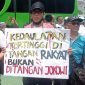 Seorang massa aksi di depan Gedung DPR RI Senayan membentangkan poster tuntutan dalam aksi massa yang berlangsung pada Jum'at (1/2/2024). Foto: Rizky Pratama Saputra, Kabarindonesia.co
