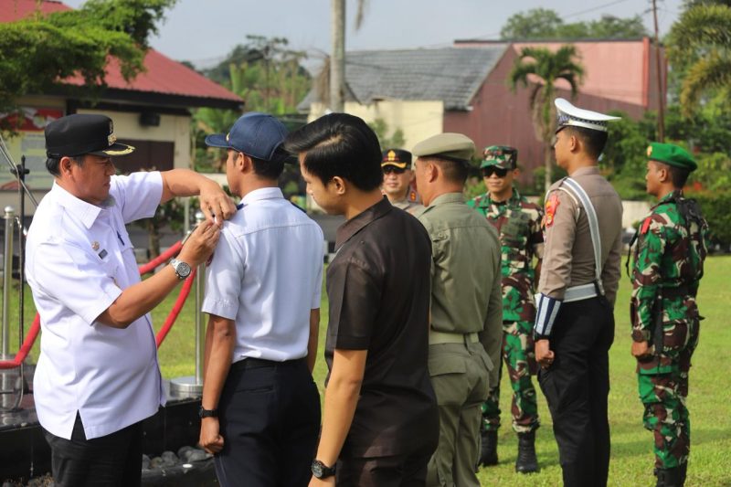 Pj. Bupati Lampung Barat, Nukman menyematkan pita pada apel gelar pasukan Operasi Ketupat 2024 di Mapolres setempat pada Rabu (3/4/2024). Foto: Haeruel Abadi, Kabarindonesia.co